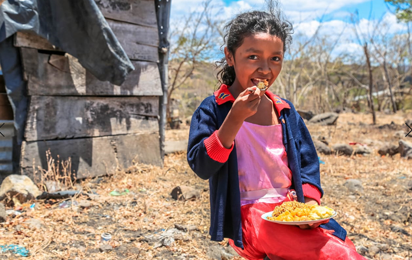 A girl eating a bowl of food