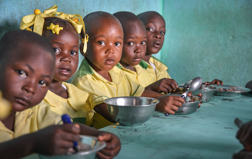 5 children sit at a table eating FMSC food