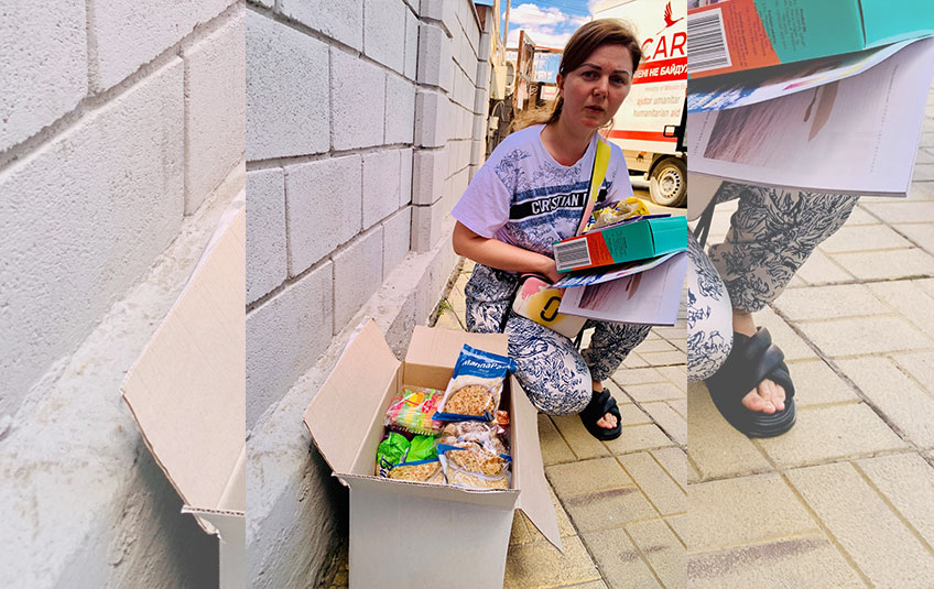 A Ukrainian refugee opens a box containing FMSC food