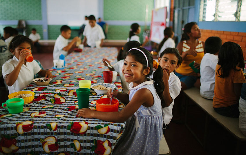 Children sitting at a table eating FMSC food