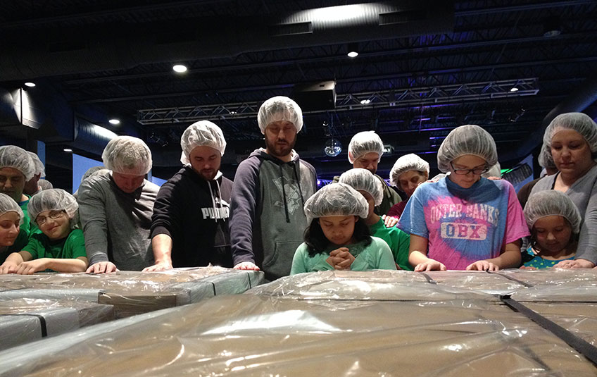 volunteers praying over a shipment of FMSC food