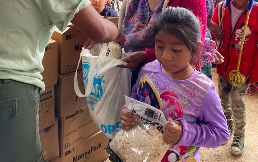 A girl holds a bag of MannaPack Rice