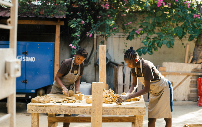 Two FMSC artisans crafting with clay 