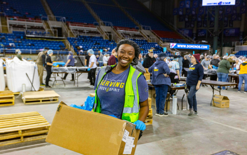 Woman holding box volunteering at a FMSC MobilePack