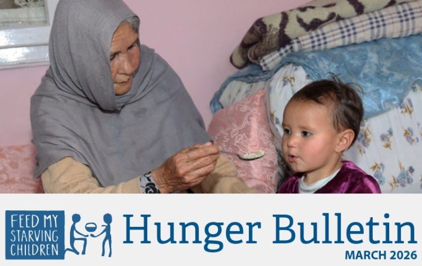 march hunger bulletin woman feeds child spoon of rice