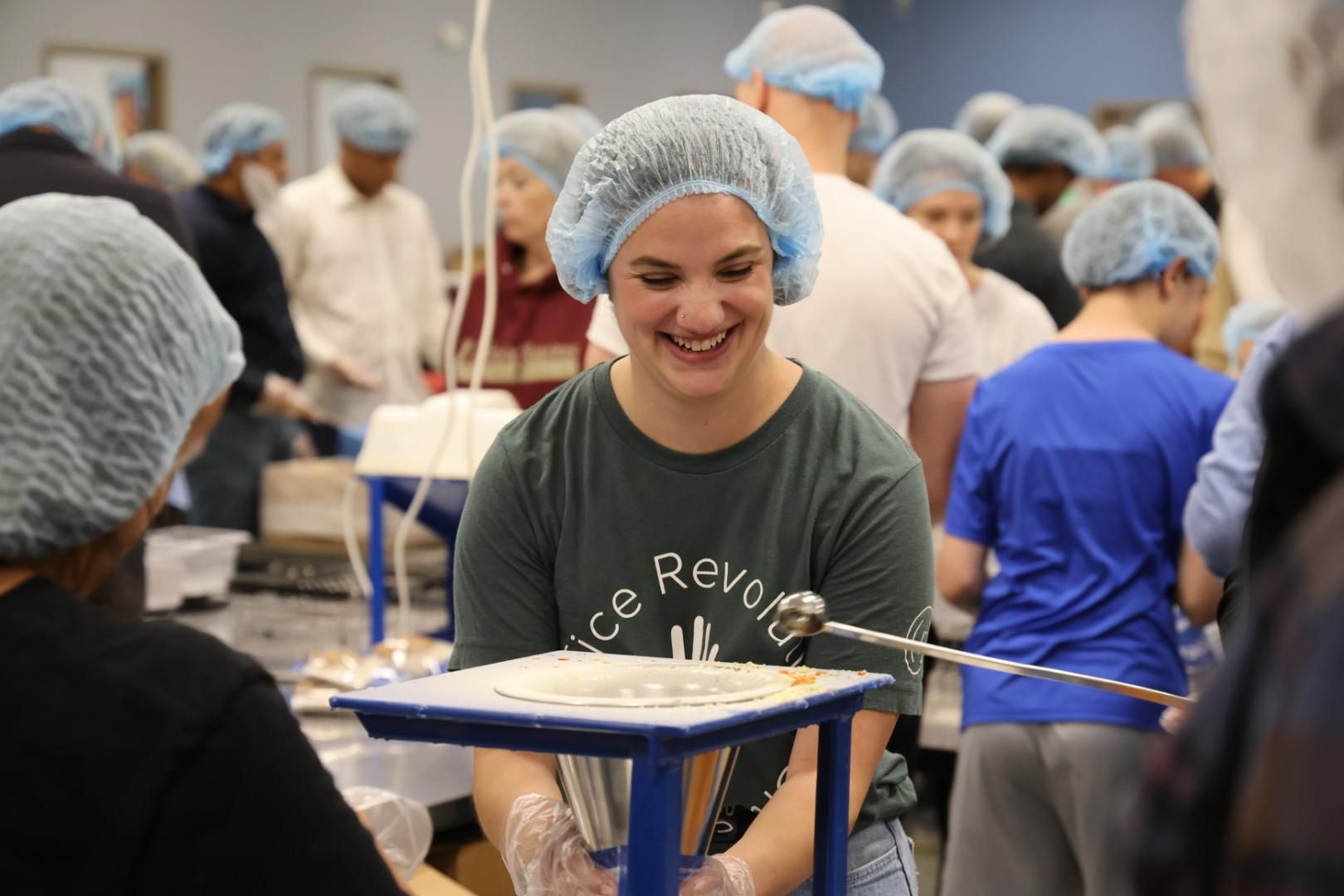 young woman in hairnet packing food at teen volunteering opportunity
