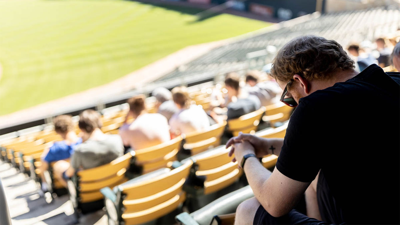 volunteer praying at FMSC packing event at Target Field