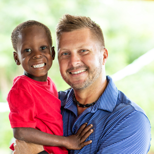 Haiti Bible Mission CEO Mark Stockeland holding a child