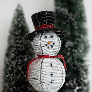 A snowman in front of evergreens