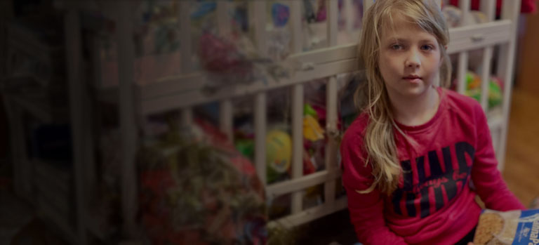 A Ukrainian girl sits holding a bag of MannaPack Rice