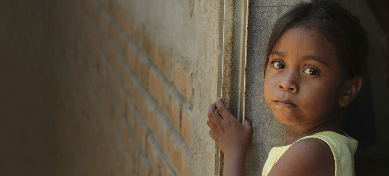 A child looks longingly at the camera
