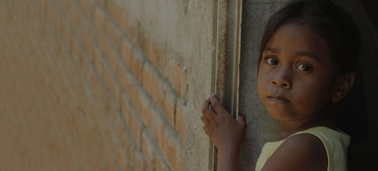 A child looks longingly at the camera