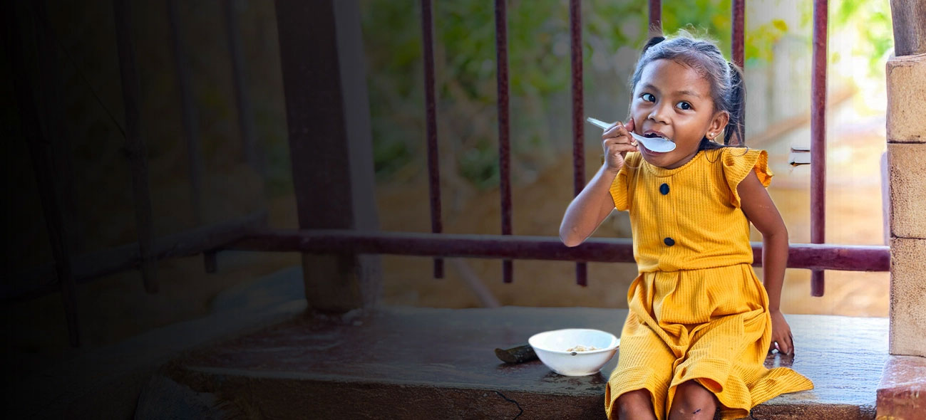 A girl in the Philippines eats FMSC food